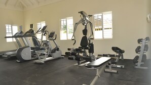 Ein Fitnessstudio mit Laufbändern, Crosstrainern und Gewichten.