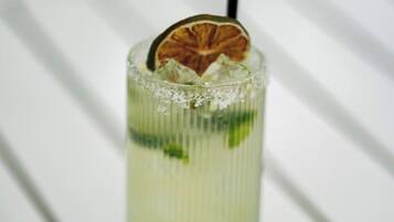 A clear glass with a lime slice and ice cubes.