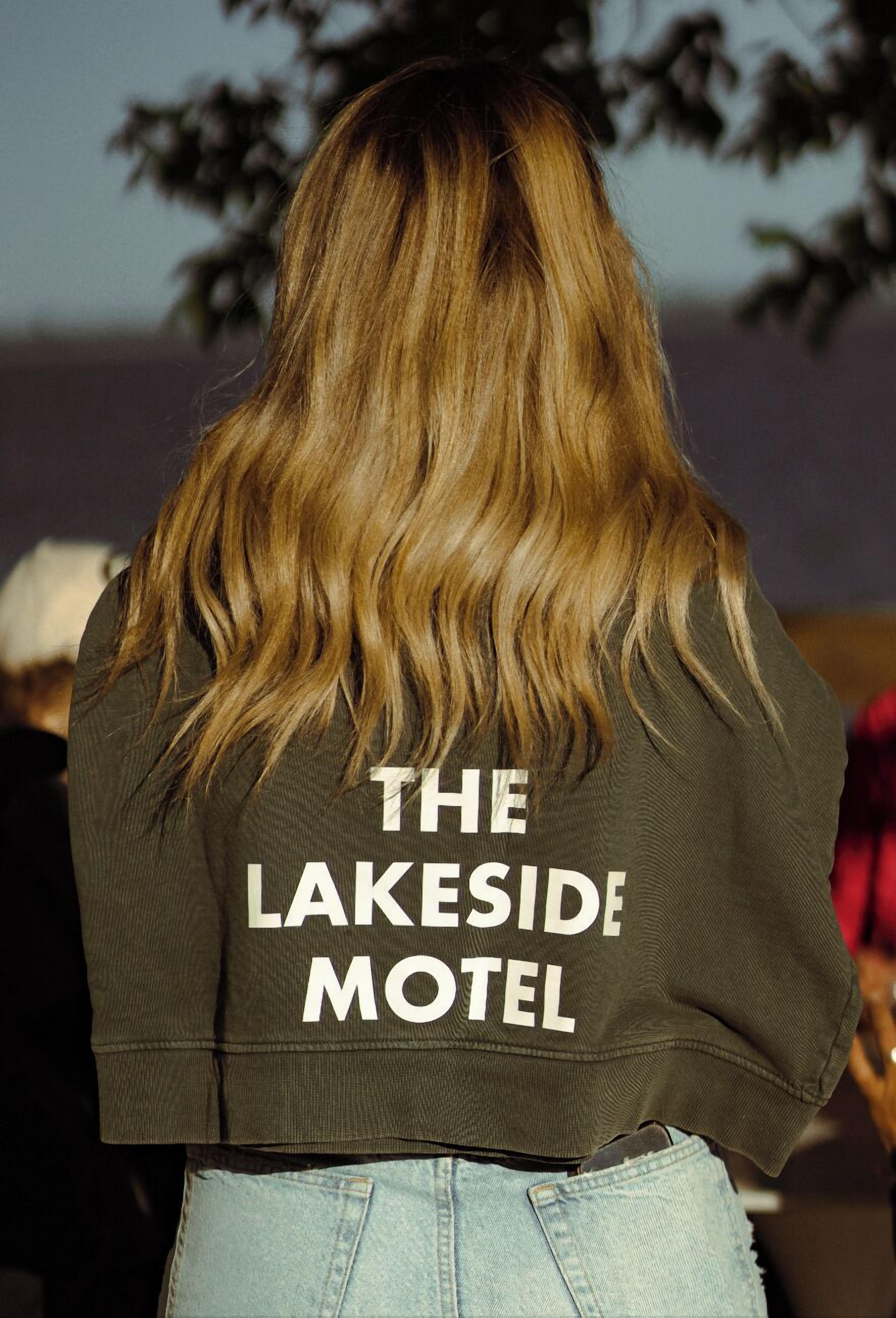 Eine Person trägt eine Jacke mit dem Aufdruck "THE LAKESIDEMOTEL" auf dem Rücken.