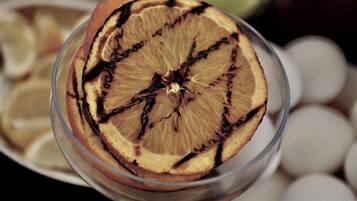 A glass containing a dried slice of citrus fruit with darkened edges.