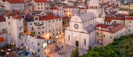 A historic town square with a prominent church featuring a dome and clock tower.
