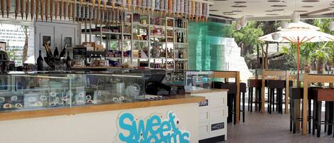 A bakery with a display of baked goods and a counter with a sign reading "Sweet Dreams Cake House".