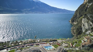 Un complejo turístico con piscina, rodeado de exuberante vegetación y con montañas al fondo.