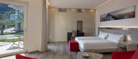 A modern hotel room with a bed, a desk, a chair, and a dining table.