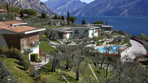 A residential area with modern houses, a swimming pool, and a mountain backdrop. - Hotel Atilius Adults Only (Limone sul Garda)