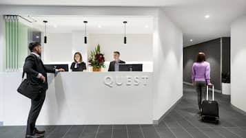Een modern receptiebalie met het woord "QUEST" duidelijk in het zicht.