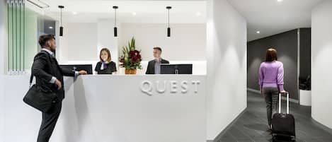 A modern reception desk with the word "QUEST" prominently displayed.