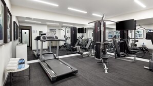 A modern gym with treadmills, weight machines, and a mirrored wall. - Quest St Kilda Road (Melbourne)