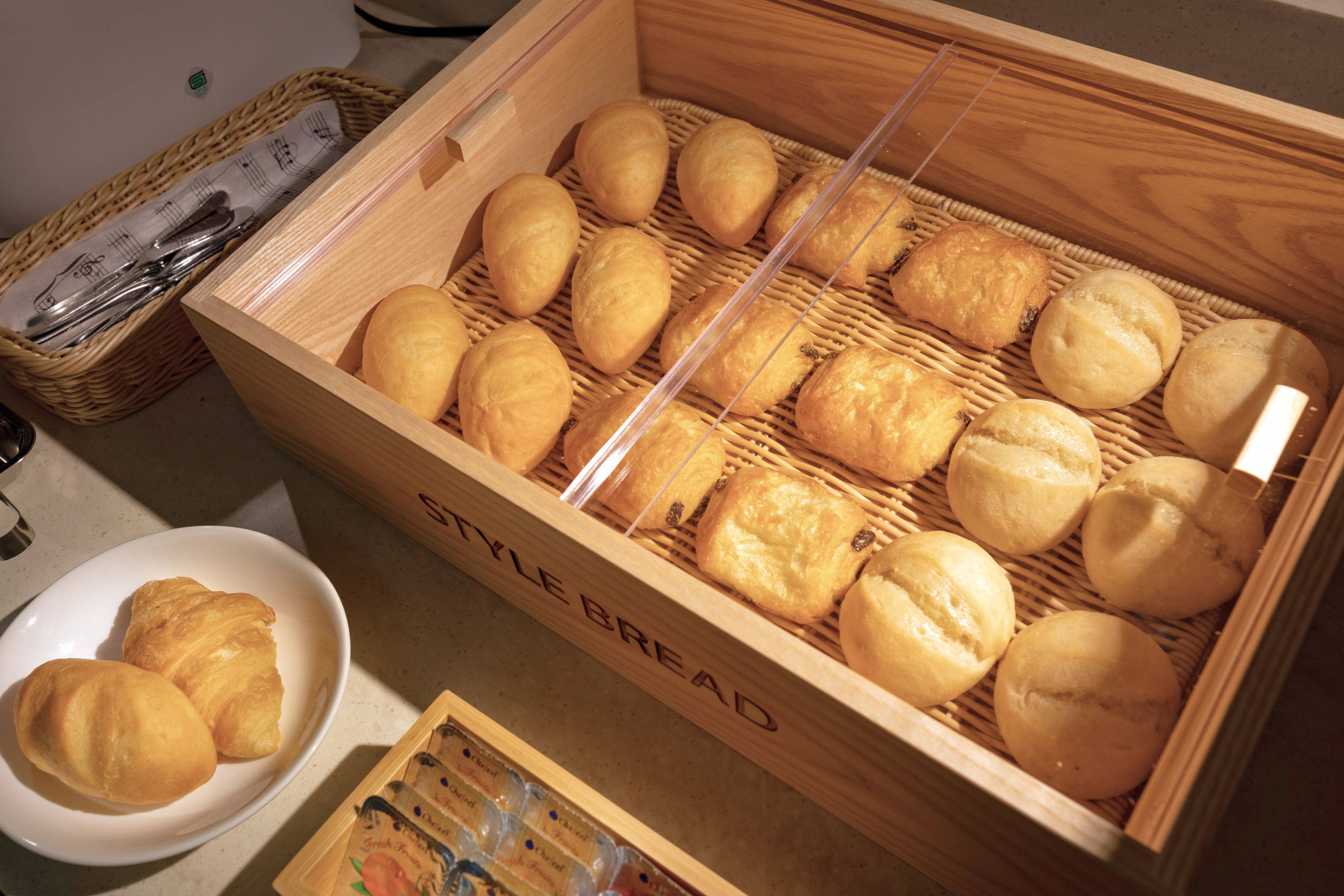 A wooden bread box with a label 'STYLE BREAD' containing several loaves of bread.