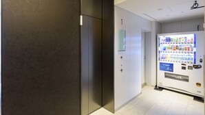 A hallway with a vending machine and a door with a sign. - Best Western Hotel Fino Tokyo Akihabara (Tokyo)