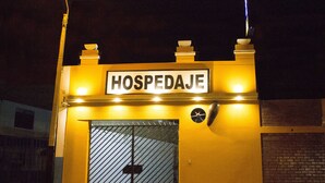 Un edificio con un letrero que dice "HOSPEDAJE" durante la noche.