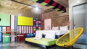 A room with a bed, a yellow chair, and a small table with chairs. - D522 Hostel at Kiener Hills - Near Cebu Airport (Lapu-Lapu)