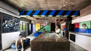 A modern kitchen with a central island, a chalkboard menu, and a colorful wall design. - D522 Hostel at Kiener Hills - Near Cebu Airport (Lapu-Lapu)
