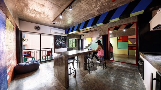A modern kitchen with a bar area, a seating area with stools, and a large window providing a view of the outside. - D522 Hostel at Kiener Hills - Near Cebu Airport (Lapu-Lapu)