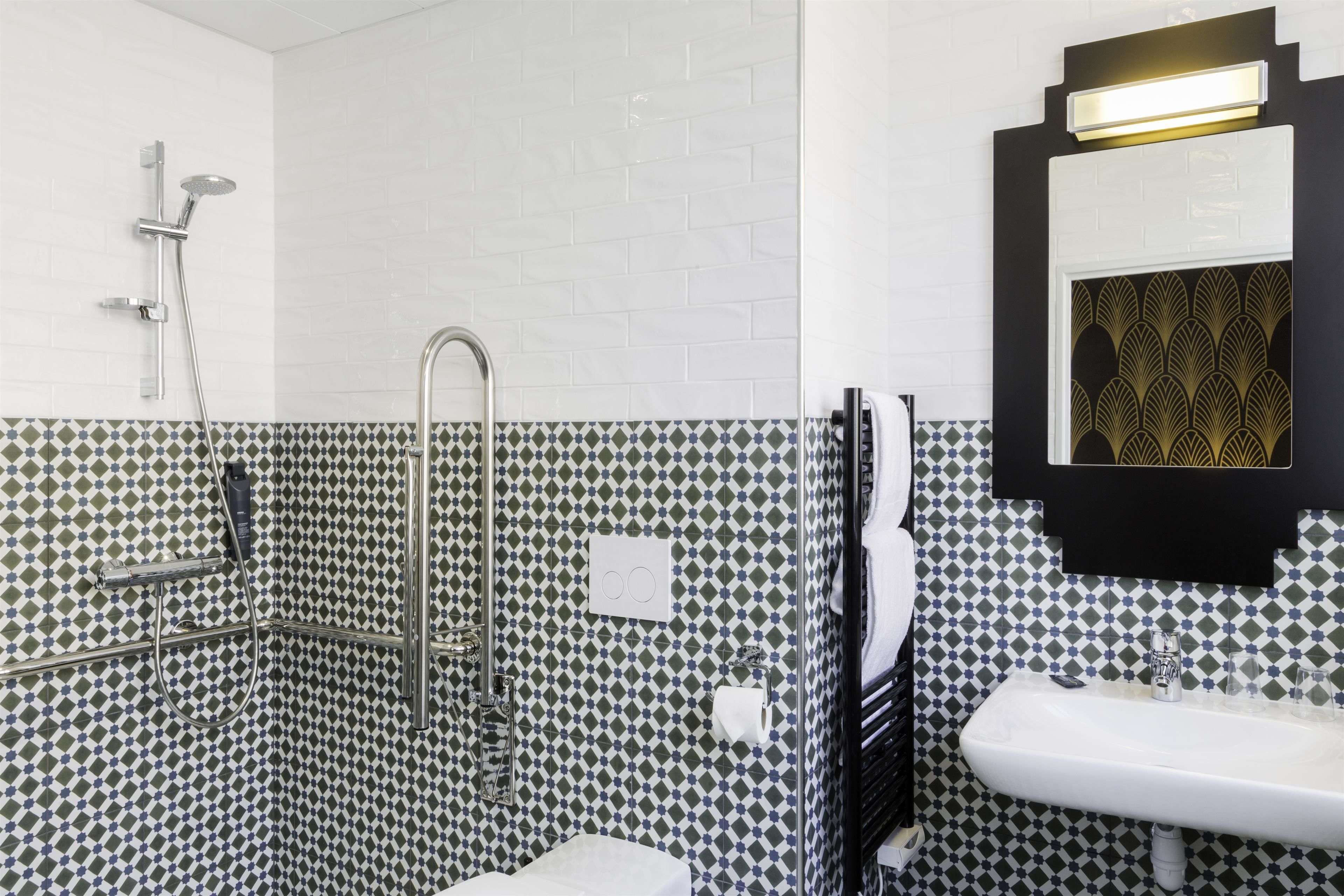 Un baño con ducha, lavamanos y espejo.