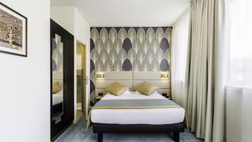 Una habitación de hotel moderna con una cama grande, un adorno en la pared y vistas al exterior.