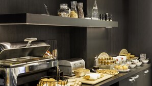 Montaje de bufé con diversos alimentos, un tostador y una estación de café.