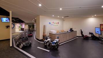 A modern reception area with a play area featuring toy cars and a motorcycle.