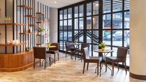 A modern interior with a reception desk, seating area, and large windows.