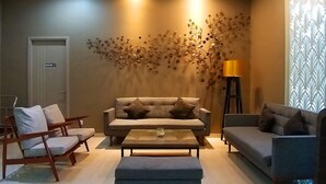 A living room with a sofa, two armchairs, a coffee table, and a floor lamp.