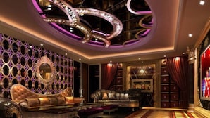 Un interior lujoso con muebles ornamentados, una alfombra estampada y un techo decorativo.