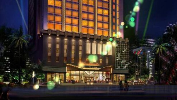 Un hotel de gran altura con varios pisos, una entrada destacada y una fachada bien iluminada.