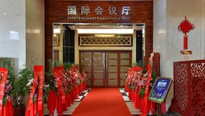 La entrada del Centro de Convenciones Internacional, con alfombra roja y decoración floral.