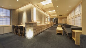 A modern hotel lobby with a reception desk, seating area, and a view of the city through large windows. - Narano Mori Hotel (Nara)