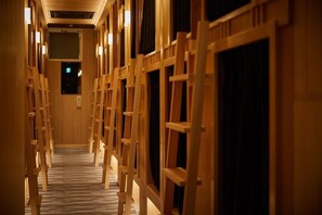 A corridor with wooden frames and a carpeted floor, leading to a darkened area at the end.