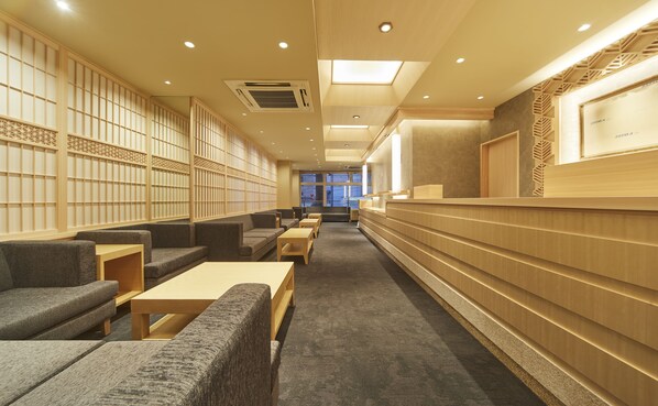 A modern library with seating areas, bookshelves, and a reception desk.