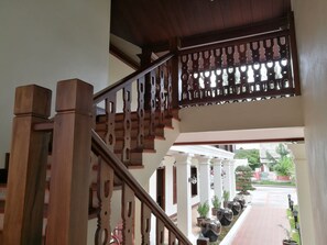 Staircase leads to an upper level, flanked by traditional pillars and columns.