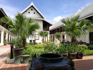 Stroll through this serene courtyard, surrounded by lush greenery and ornate details.
