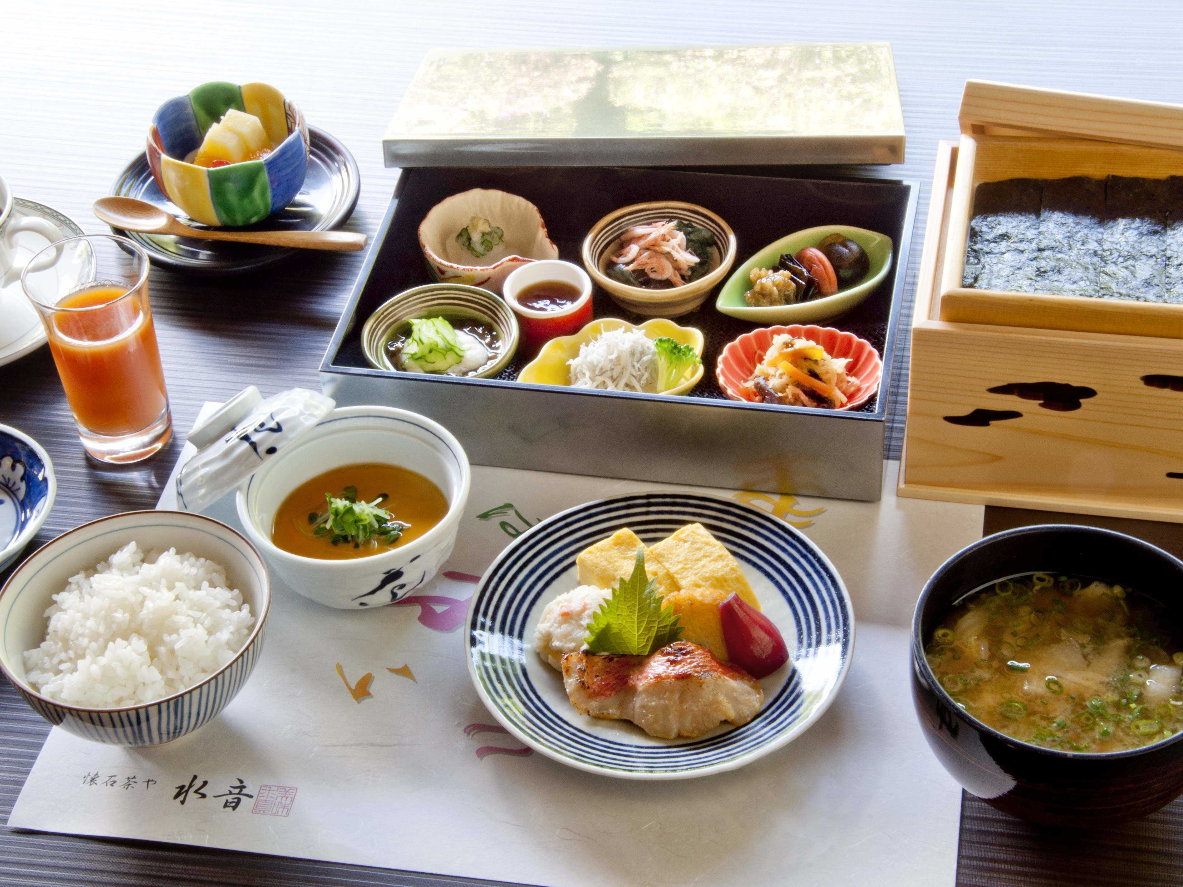 A traditional Japanese meal with various dishes including rice, fish, and soup.