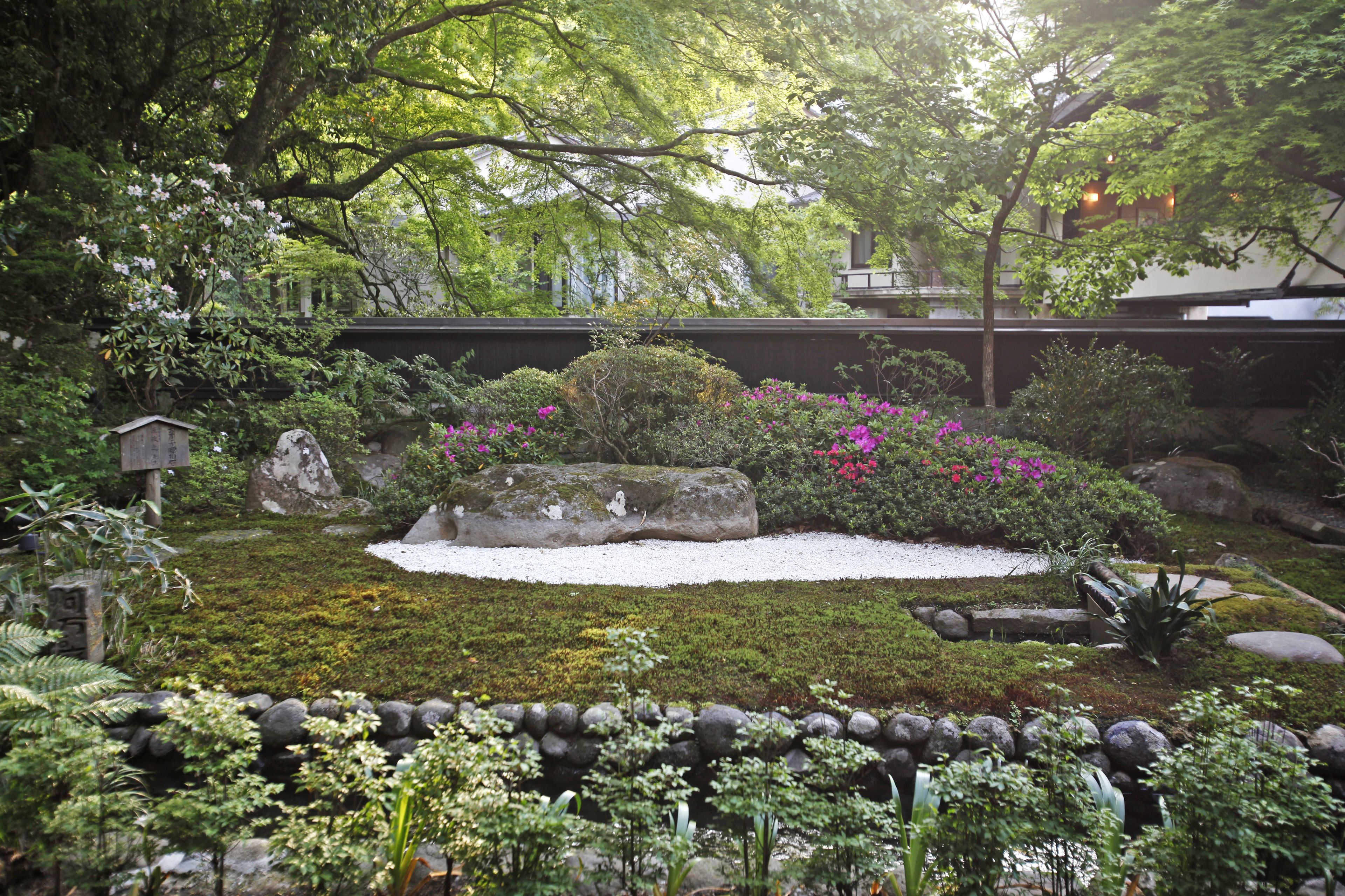 A traditional Japanese garden with a koi pond, stone lanterns, and lush greenery.