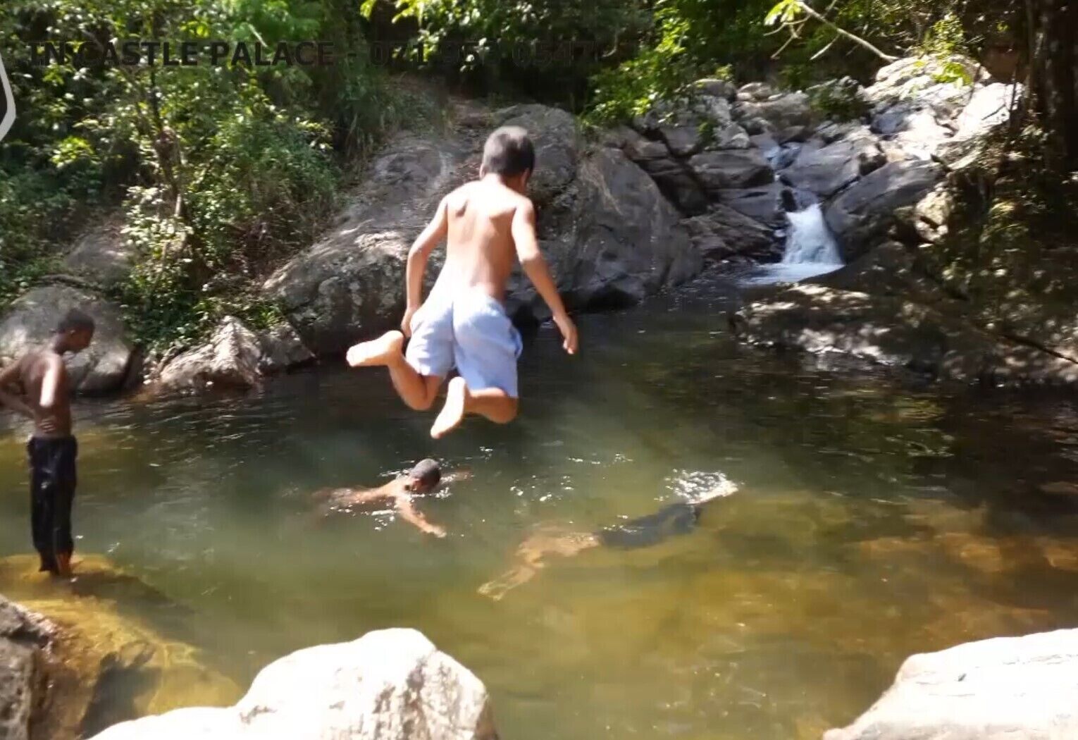 A natural setting with a rocky water body and a waterfall.
