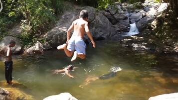 A natural setting with a rocky water body and a waterfall.