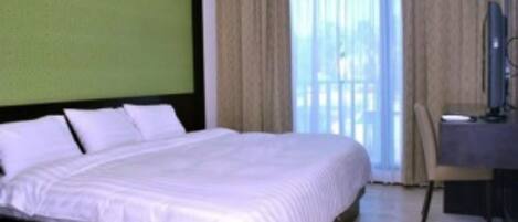 Una habitación de hotel con una cama grande, un escritorio y una silla.