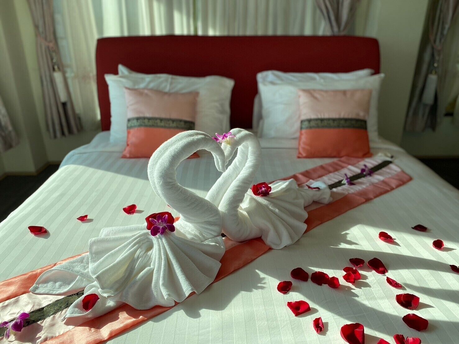 Habitación de hotel con cama, almohadas y una decoración de toallas.