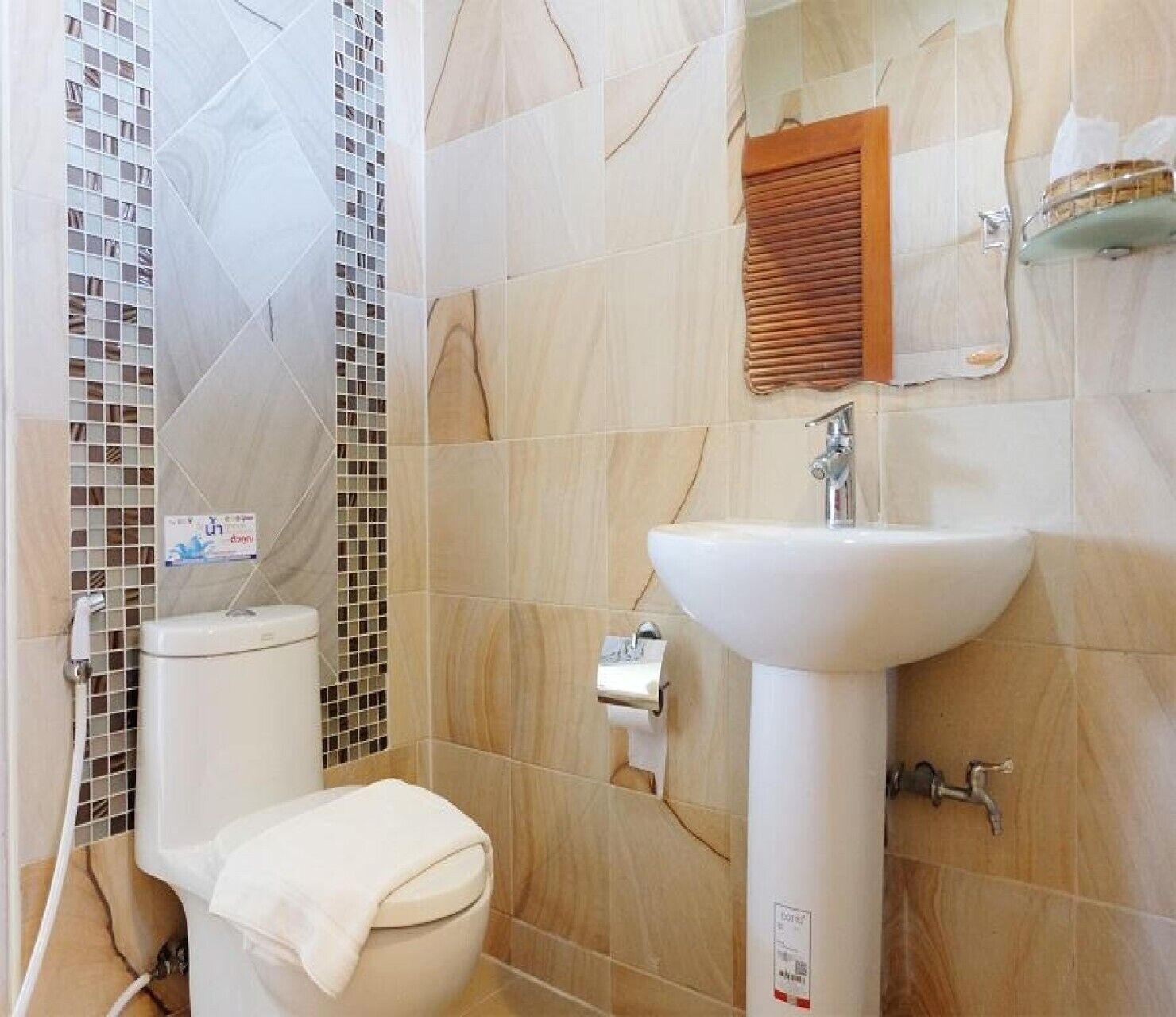 Une salle de bain comprenant des toilettes, un lavabo et un espace douche.