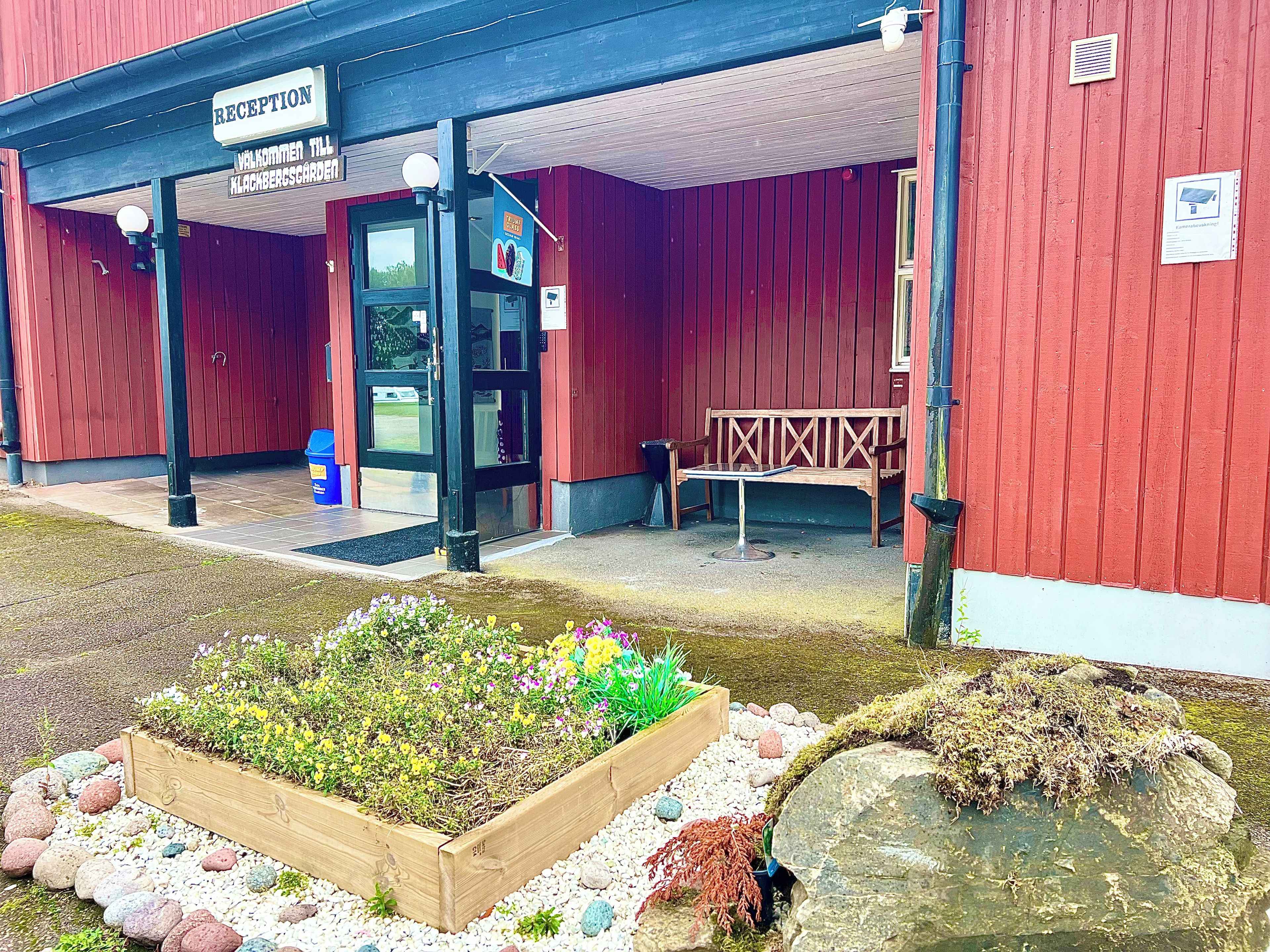 A reception area with a wooden bench and a sign indicating a welcome to a specific location.