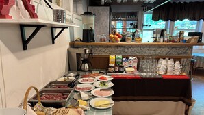 En buffet med forskellige retter, bestik og tilbehør.