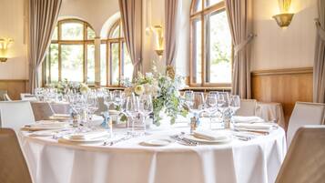 Une table ronde dressée pour un événement formel, avec des marque-places numérotés et un centre de table floral.