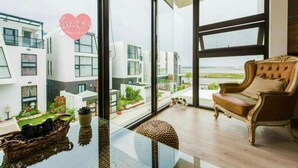 Un salon moderne doté d’une grande baie vitrée, d’un fauteuil confortable et d’une table en verre.