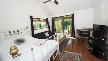 Une chambre à coucher avec un lit, un bureau, une télévision et une vue sur l’extérieur.