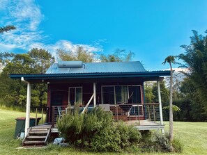 A single-story house with a porch, a chimney, and a small deck. - Nimbin Waterfall Retreat (Nimbin)
