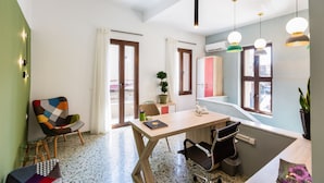 A modern kitchen with a wooden table, a chair, and pendant lights. - Ark 68 City Rooms (Rethymno)
