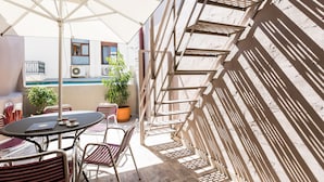 An outdoor patio with a table, chairs, and a potted plant. - Ark 68 City Rooms (Rethymno)