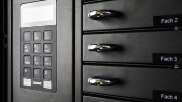 A close-up of a keypad with a screen and a set of drawers labeled "Fach 2," "Fach 3," and "Fach 4."