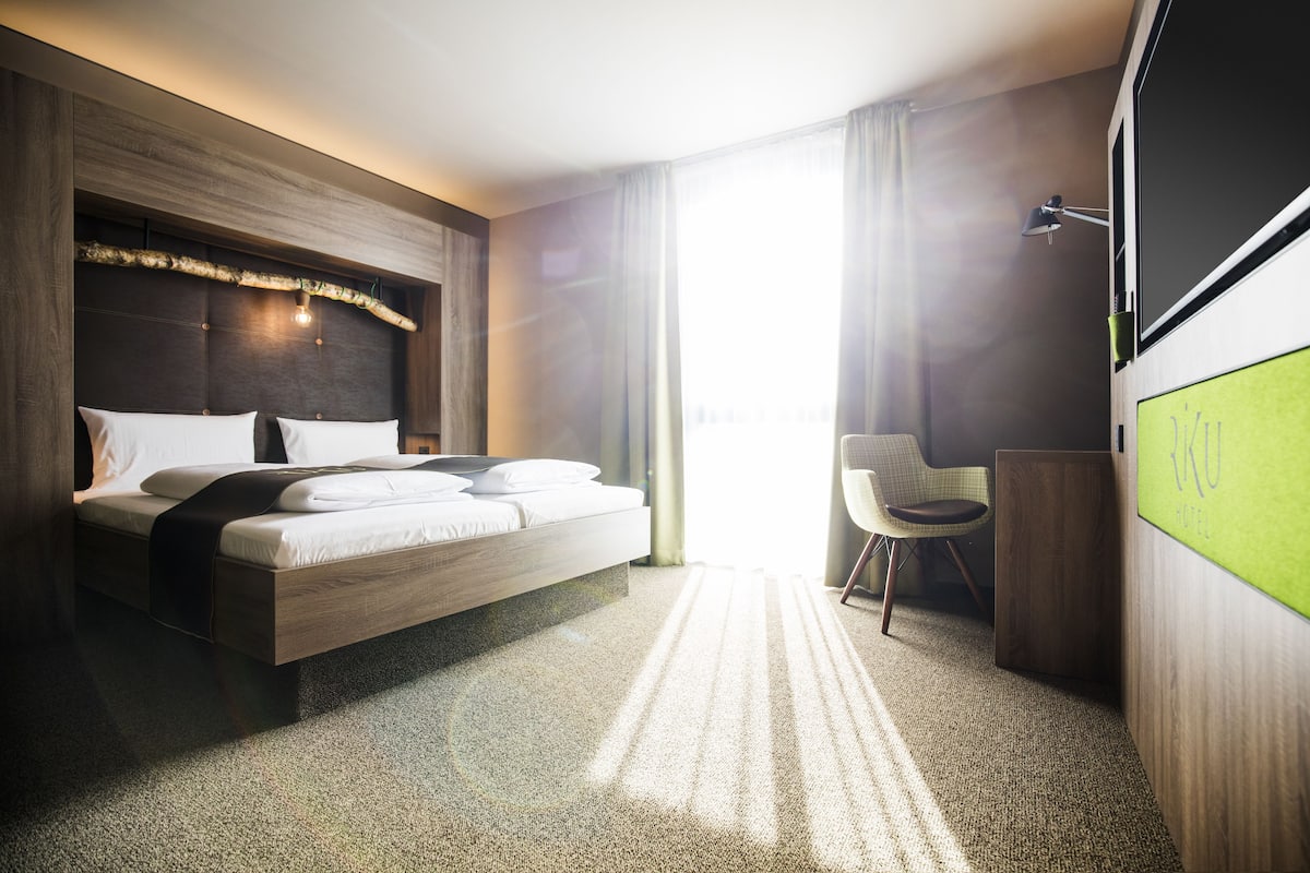 Biancheria da letto ipoallergenica, una scrivania, tende oscuranti