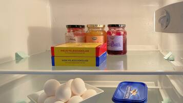 A refrigerator with two boxes of Mörk Pälägschokolade, two jars of Fynbo Classic, and a container of Kergarden.